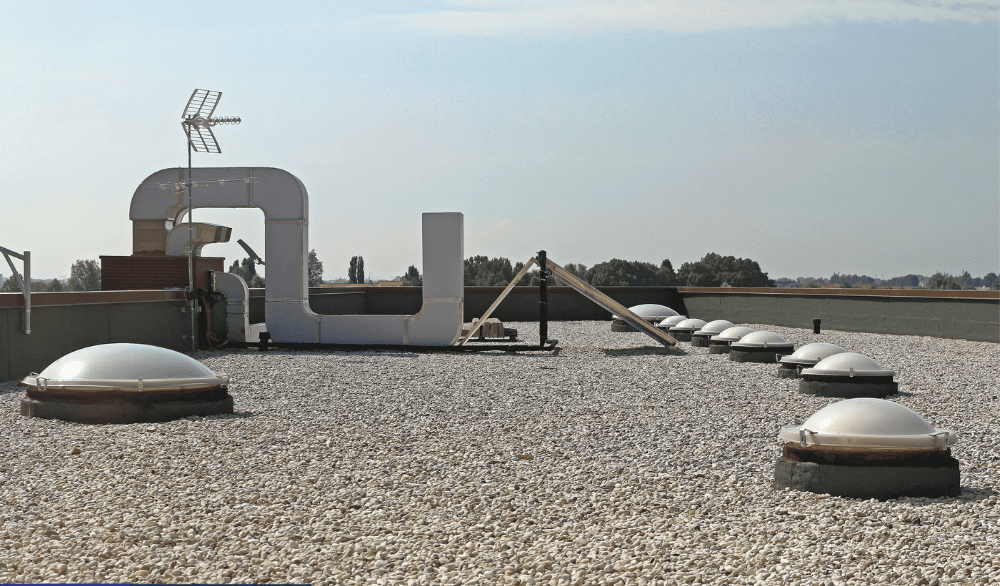 A large white sign sitting on top of a gravel field.