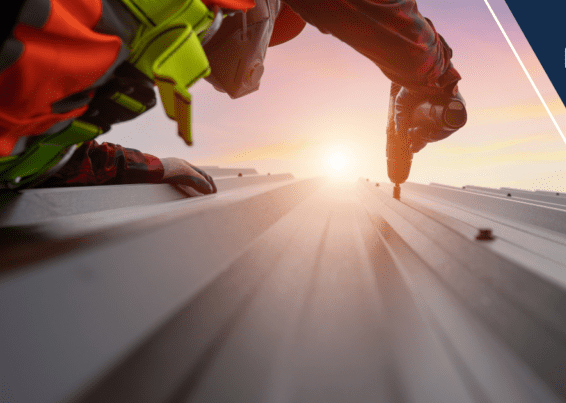 A construction worker is working on the roof of a building.