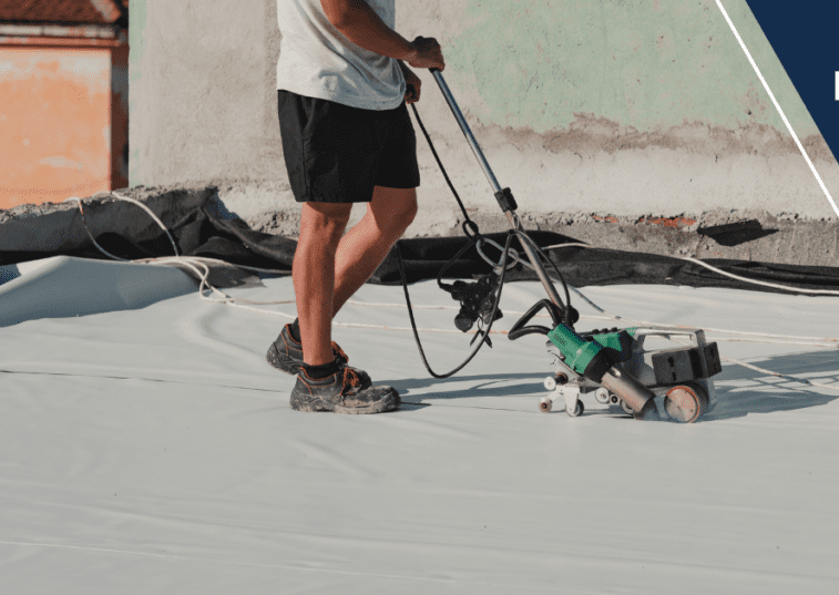 A man is using a power tool to paint the roof of a building.