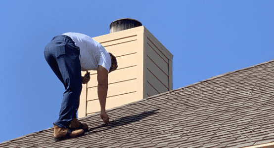 A man working on the roof of his home.