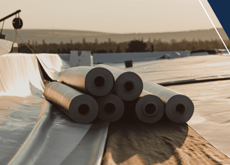 A bunch of rolls of roofing material on the roof.